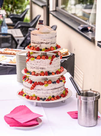 beautiful delicious Wedding cake in many tiers with fresh wild berries and fruitsの写真素材