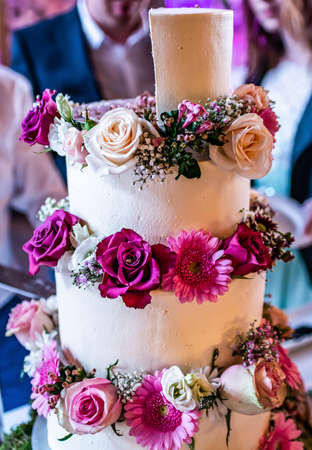 beautiful delicious Wedding cake in many tiers with fresh wild flowers and roses.の写真素材