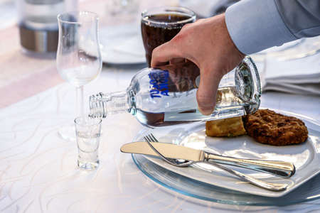 06.07.2019 Koblenz Germany hand with a bottle of Absolut Vodka poured into a shot glass isolated during a party weddingのeditorial素材