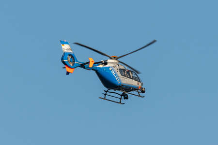 Germany Koblenz 05.04.2020 D-HRPB police helicopter flies over the city in blue sky background searching for suspectのeditorial素材