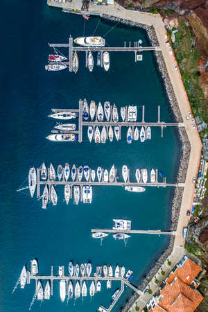 The drone aerial view of sailing yachts moored in marina Quinta do Lorde on coast of the Portuguese island of Madeiraの写真素材