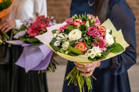 Wedding bouquet of flowers held by bride closeup. Pink and yellow roses flowersの写真素材