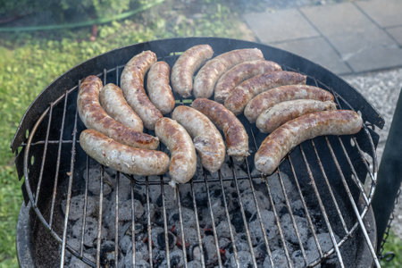 Barbecue grill bbq on coal charcoal grill with raw bratwurst sausages meat delicious summer mealの写真素材
