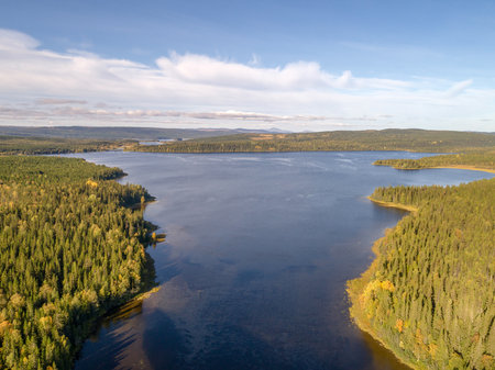 Aerial view famous waterfall Tannforsen northern Sweden, with a rainbow in the mist and rapid flowing cascades of waterの写真素材
