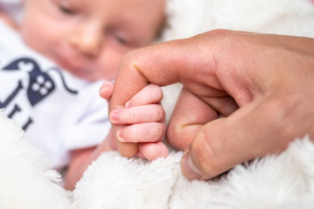 sweet tiny new born baby hand hold mum index finger. concept relationship between mother or parants...