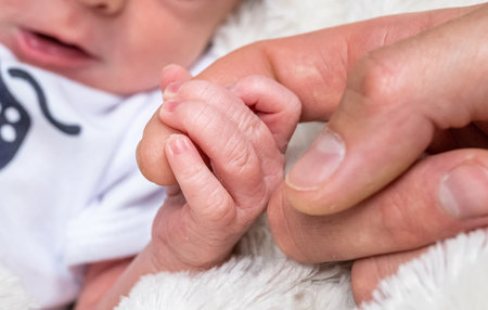 sweet tiny new born baby hand hold mum index finger. concept relationship between mother or parants and babyの写真素材