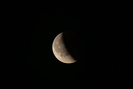 Lunar eclipse beginning close-up right corner sun begins to come on top of moon lunar eclipse black...