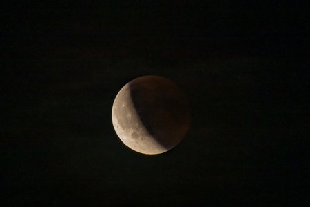 Lunar eclipse beginning close-up right corner sun begins to come on top of moon lunar eclipse black...