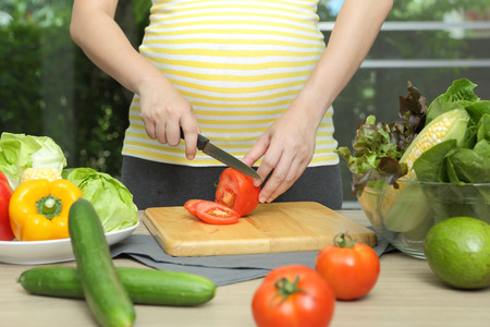 Pregnant woman is cookingの写真素材