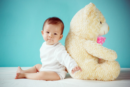 Happy girl playing with teddy bearの写真素材