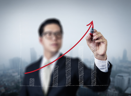Businessman hand writing graph of growth, new business concept, studio shotの写真素材