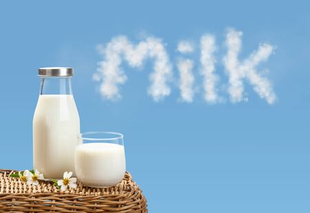 A bottle of rustic milk and glass of milk on wicker on a blue sky background, tasty, nutritious and healthy dairy productsの写真素材