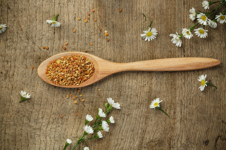 Bee pollen with wooden spoon and flowerの写真素材