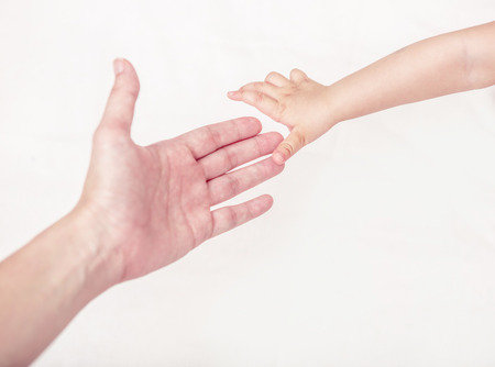 Close up of mother and babies hands touching with finger .Isolated on white.の写真素材