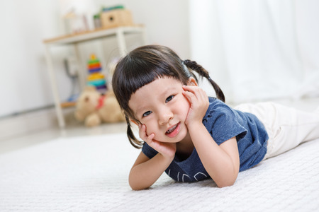 Preschooler girl learns at school. Cute child playing with teddy bear. Little girl having fun indoors at home, kindergarten or day care. Educational concept for school kids.の写真素材