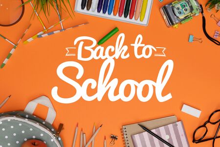 Creative flat lay of stationery orange table with backpack on orangeの写真素材