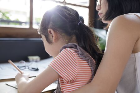 Businesswoman mother woman with a child girl working on the desk in the home, Quarantine isolation...