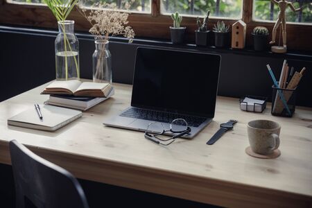 Modern home office creative space perfect for working from home lifestyle with laptop on the desk and sofa in the living room, Quarantine isolation during the  health crisisの写真素材