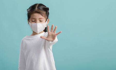 Asian little child girl is wearing medical face masks to protect themselves from pollution Coronavirus flu virus, New coronavirus 2019-nCoV   , Empty space isolated on blue long bannerの写真素材