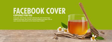 Honey in jar with bee and honey dipper on wooden table isolate on green banner background, bee products by organic natural ingredients conceptの写真素材