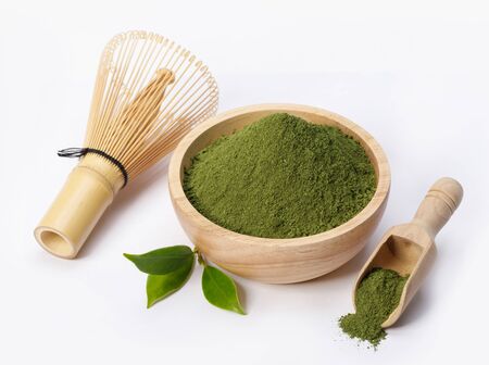 Matcha green tea powder in bowl with Organic green tea leaf and Japanese wire whisk isolated on white background, Organic product from the nature for healthy with traditional styleの写真素材