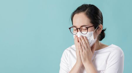 Asian young girl is wearing medical face masks to protect themselves from pollution Coronavirus flu virus, New coronavirus 2019-nCoV from China, Empty space isolated on blue long bannerの写真素材