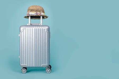 Travel Baggage with hat isolated on blue background with copy space, Travel concept backgroundの写真素材