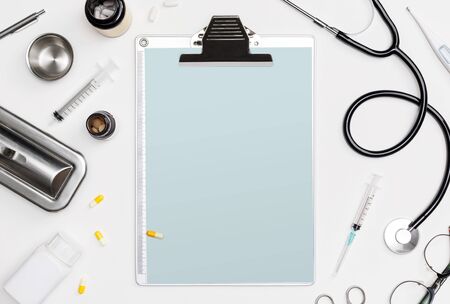 Doctor medical equipment white backgroud with stethoscope, medical documents, thermometer, syringe and pills with copy space mockup templateの写真素材