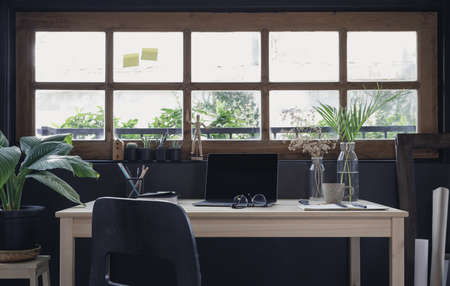 Modern home office creative space perfect for working from home lifestyle with laptop on the desk and sofa in the living room, Quarantine isolation during the Coronavirus (COVID-19) health crisisの写真素材