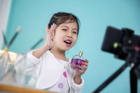 Cute little girl beauty vlogger live video streaming and review product.の写真素材