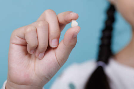 Child's hand holding first tooth milk, Dentistry and Health care concept