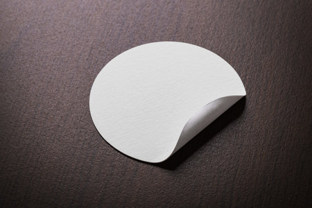 Rounded sticker mockup template on wooden desk with copy space for your logo or graphic designの写真素材