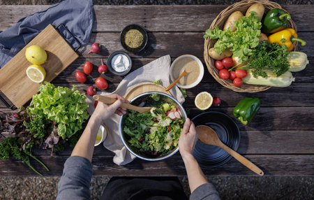A woman enjoys a healthy salad at a restaurant during a delicious dinner, surrounded by a beautifully set table and gourmet dishes, creating a perfect scene for a banquet or partyの写真素材