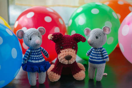 Amigurumi dolls two gray mice a puppy and a kitten are photographed at the window with colorful balls.の写真素材