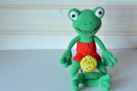 Amigurumi doll frog red shorts sitting.の写真素材