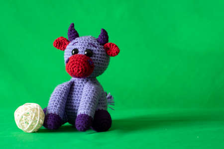 Doll amigurumi bull on a green background.の写真素材