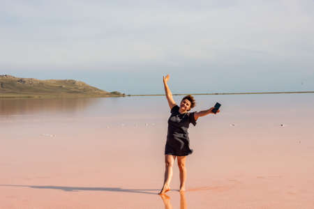 A middle-aged woman expresses delight on vacation in a salt lake.の写真素材