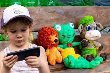 A little girl holding a smartphone in her handsの写真素材