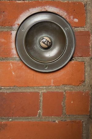 large old fashioned doorbell mounted on brick wall with button marked pressの写真素材