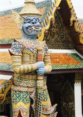 ornately decorated giant statue greets visitors to an elaborately decorated temple in the grand palace bangkok thailandの写真素材