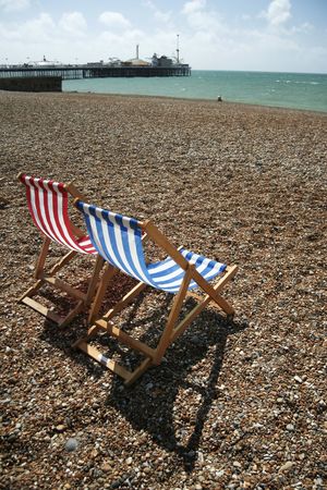 pebble beach with striped canvas deckchairs, brighton, englandの写真素材