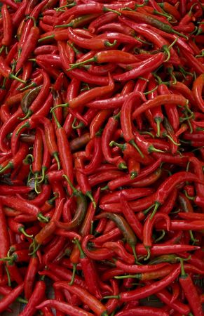 lots of fresh large red spicy chillis shot from overhead at outdoors market in kota kinabalu...