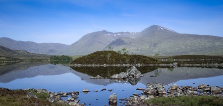 mountains reflecting in the still waters of lakes on rannoch moor in the scottish highlandsの写真素材