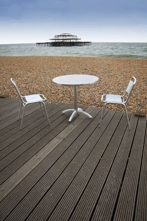 tabel and chairs on wooden decking of outdoor cafe on brighton beach east sussex englandの写真素材