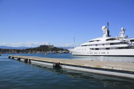 white superyacht at anchor in antibes harbour overlooked by castle in the cote d'azure in the south of franceのeditorial素材