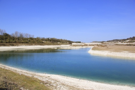 blue sky reflected in the lake created in disused chalk quarry at pitstone cement works buckinghamshire with ivinghoe beacon behindの写真素材