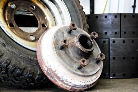 well worn old wheel removed from truck in garage workshopの写真素材
