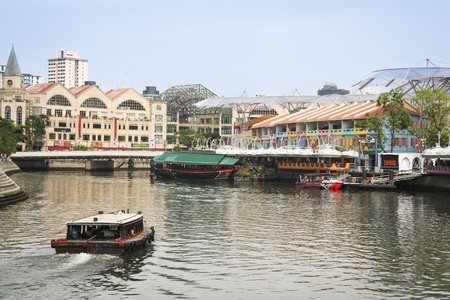 Clarke Quay, Singapore City,  May 11, 2008 - Tourist boat crusing the Singapore river past Riverside...