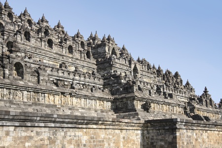 ornately decorated walls of ancient stone pyramid in borobudur temple complex in yogyakarta, java indonesiaの写真素材