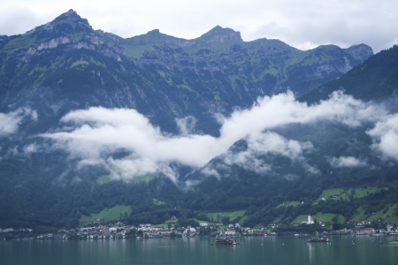 traditional swiss alpine village by the side of lake at the foot of high mountainsの写真素材